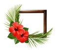 Red hibiscus flowers and palm leaves in corner tropical arrangement on wooden frame Royalty Free Stock Photo