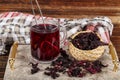 Red hibiscus tea in glass cup on white wooden table with dry rose petals. Hibiscus tea background Royalty Free Stock Photo