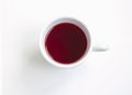 Red hibiscus tea in a white cup