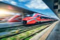 Red high speed train in motion on the railway station at sunset Royalty Free Stock Photo