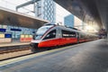 Red high speed train in motion on the railway station at sunset Royalty Free Stock Photo