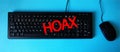 Red Hoax word on keyboard button top view. Computer keyboard key with danger sign with words Internet Hoax. Royalty Free Stock Photo