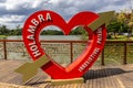 Red Holambra heart sign on the wooden deck of a bridge with padlocks, Sao Paulo