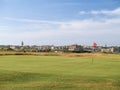 Red hole flag on golf course with urban skyline behind Royalty Free Stock Photo