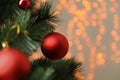 Red holiday bauble hanging on Christmas tree against blurred festive lights, closeup. Space for text Royalty Free Stock Photo
