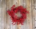 Red holly berry wreath on aged wooden boards Royalty Free Stock Photo