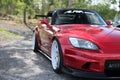 Red Honda s2000 with white rims standing in the shades