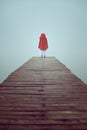 Red hood woman in a misty pier Royalty Free Stock Photo