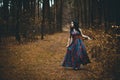 Red Hooded Woman Holding Apple Fairytale Portrait - Fairytale image of a beautiful  girl wearing a red hood near the forest Royalty Free Stock Photo
