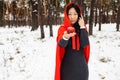 Red Hooded Woman Holding an Apple Fairytale Portrait in winter forest. Royalty Free Stock Photo