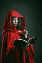 Red hooded woman reading a book