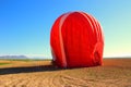 A red hot air balloon being dismantled