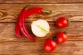 Red hot cherry and chili peppers over wooden background onion Royalty Free Stock Photo