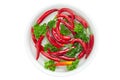 Red hot chili pepper and parsley in a dish with water. Top view, white background Royalty Free Stock Photo