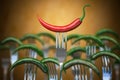 Red hot chili pepper stuck on the fork around of differents forks, Competition, unique , individuality and smile concept Royalty Free Stock Photo