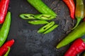 Red hot chili peppers on black board with copy space. Heap of red and green pepper. Bright natural background.