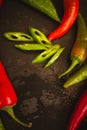 Red hot chili peppers on black board with copy space. Heap of red and green pepper. Bright natural background.