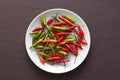 Red Hot Chili Peppers On Black and Dark Modern Background or Black Table, on a Round Plate. A Lot of Red Chilli Peppers. Green Hot Royalty Free Stock Photo