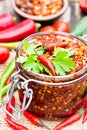 Red Hot Chili Peppers marinated in a glass jar on wooden backgr Royalty Free Stock Photo
