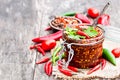 Red hot chili peppers marinated in a glass jar on wooden backgr Royalty Free Stock Photo