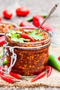 Red hot chili peppers marinated in a glass jar on wooden backgr Royalty Free Stock Photo