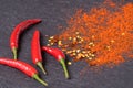 Red hot Chili peppers, red pepper flakes and chilli powder on black background Royalty Free Stock Photo