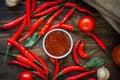 Red hot chili peppers and salsa or adjika in white ceramic bowl. Royalty Free Stock Photo