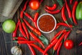 Red hot chili peppers and salsa or adjika in white ceramic bowl. Royalty Free Stock Photo