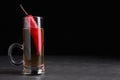 Red hot chili peppers and vodka in shot glass on grey table against black background, space for text Royalty Free Stock Photo