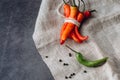 Red hot chilli chilies pepper bunch, tied by string on a gray background.