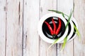 Red hot chilli pepper and green onion on plate Royalty Free Stock Photo