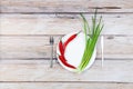 Red hot chilli pepper and scallions on plate Royalty Free Stock Photo