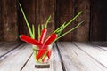 Red hot chilli peppers and green onions in glass of water Royalty Free Stock Photo