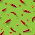 Seamless pattern made of red chili or chilli on green background. Minimal food pattern. Red hot chilli seamless peppers pattern. Royalty Free Stock Photo