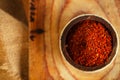 Red hot chillies pepper flakes in bowl on wooden board backgro Royalty Free Stock Photo