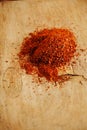 Red hot chillies pepper flakes on wooden board background Royalty Free Stock Photo