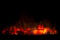 Red hot coal bars in focus on dark background with flames. Background of raw coal with soft focus Royalty Free Stock Photo