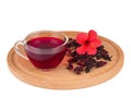Red Hot Hibiscus tea in a glass cup on a wooden board with petals of dry hibiscus and a hibiscus flower Royalty Free Stock Photo