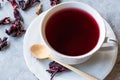 Red Hot Hibiscus Tea in White Cup with Dried Hibiscus Tea Leaves Royalty Free Stock Photo