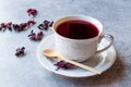 Red Hot Hibiscus Tea in White Cup with Dried Hibiscus Tea Leaves. Royalty Free Stock Photo