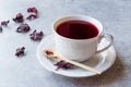 Red Hot Hibiscus Tea in White Cup with Dried Hibiscus Tea Leaves. Royalty Free Stock Photo