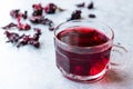 Red Hot Hibiscus Tea in White Cup with Dried Hibiscus Tea Leaves. Royalty Free Stock Photo
