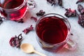 Red Hot Hibiscus Tea in White Cup with Dried Hibiscus Tea Leaves. Royalty Free Stock Photo