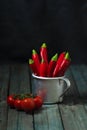 Red hot peppers in an aluminum mug on the table, tomato Royalty Free Stock Photo
