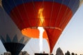 Red hotair balloon closeup before takeoff with burner flame warming the air