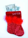 Red hottie sequined feathered christmas stocking with money Royalty Free Stock Photo