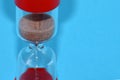 Red hourglass on a blue table. Royalty Free Stock Photo
