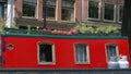 A Red housboat with flowers on the top in a Canal in Amsterdam Holland