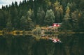 Red house in coniferous Forest with lake water reflection Landscape Royalty Free Stock Photo