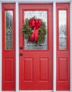 Red House Door Decorated with Pine Christmas Wreath